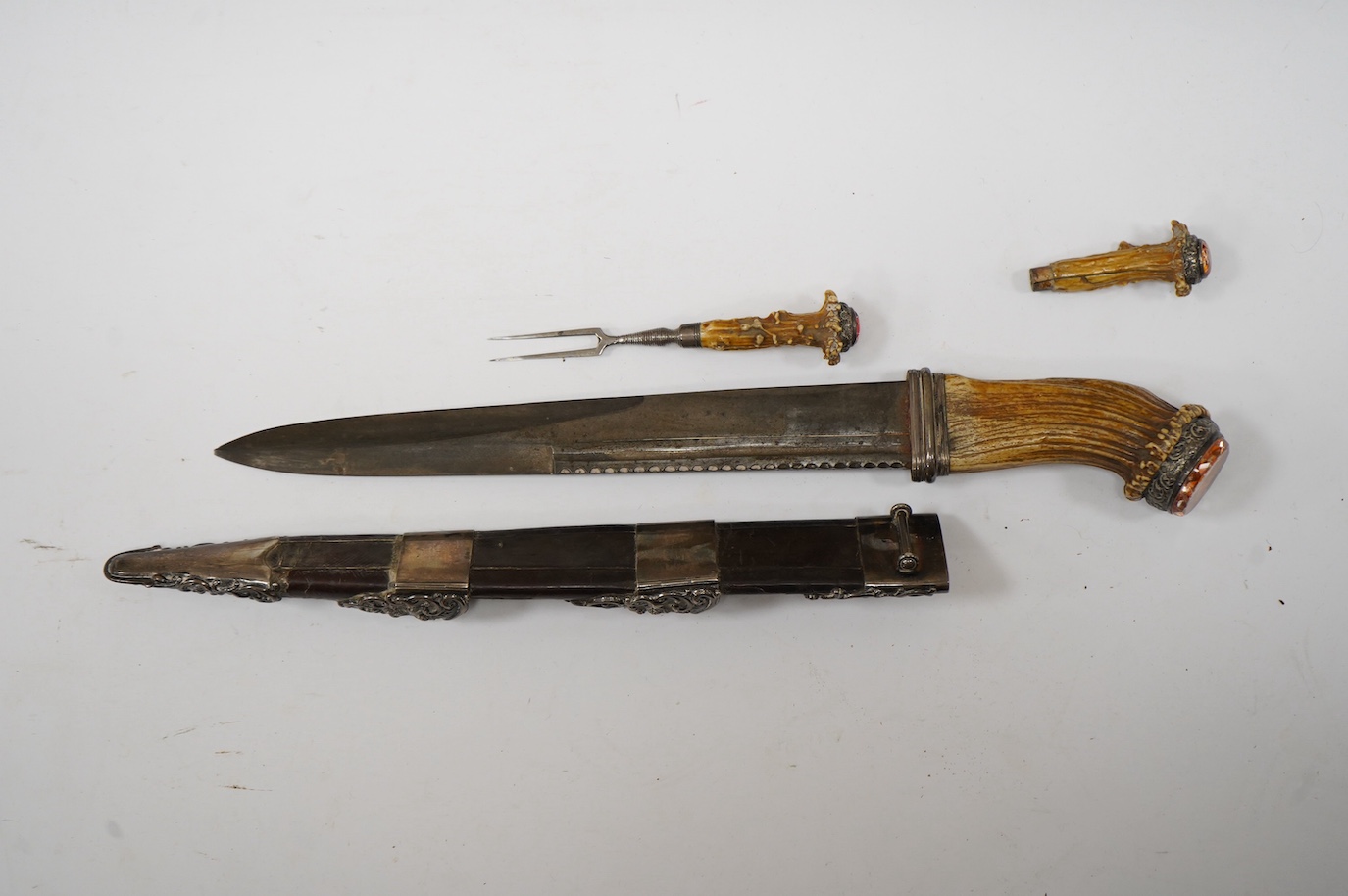 A Scottish Highland dirk, c.1900, regulation blade, staghorn handle with white metal mounts and foiled glass pommel stone, leather covered scabbard with white metal mounts embossed with thistles, containing knife and for